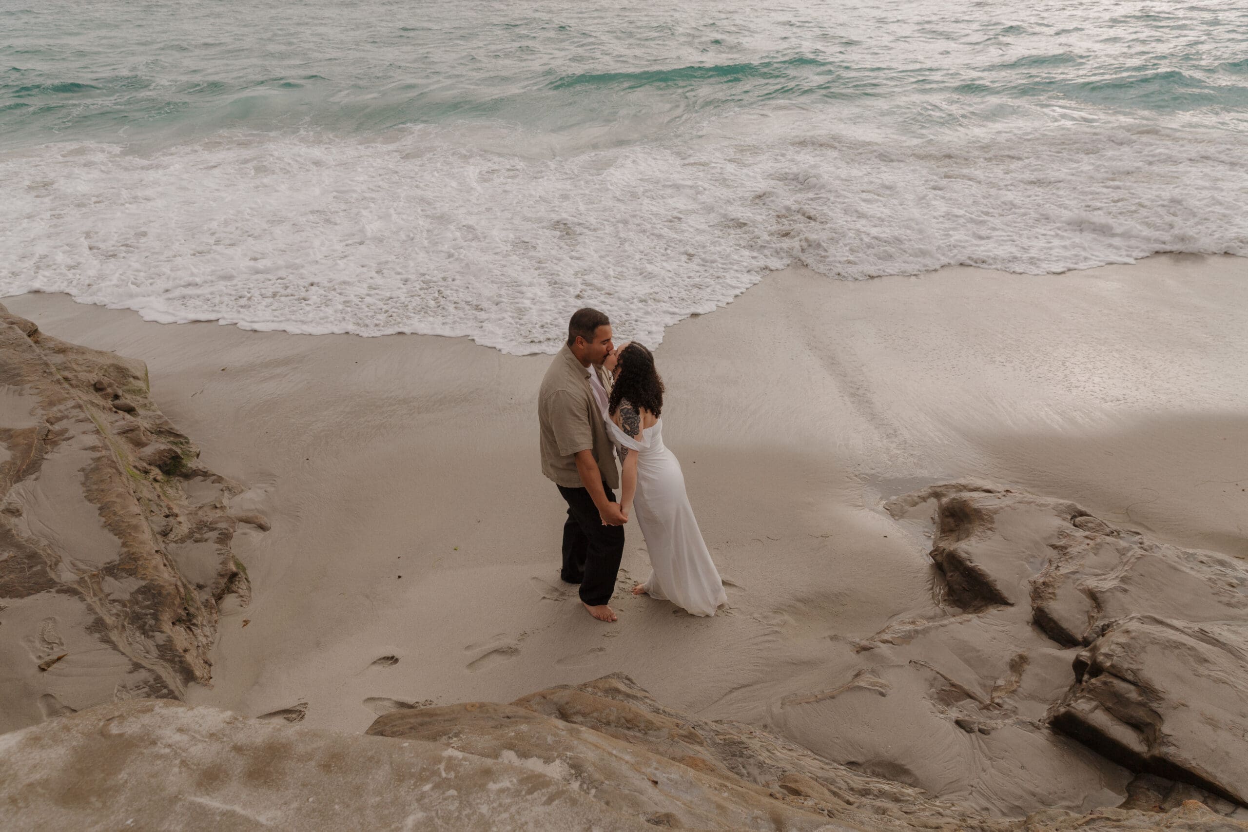 Couple sharing a kiss at Windansea Beach